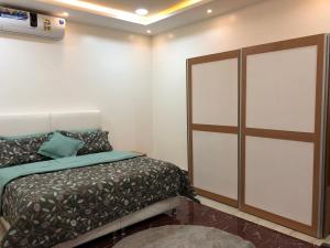 1 dormitorio con 1 cama y puerta corredera de cristal en Kendah Chalet, en Buraidah