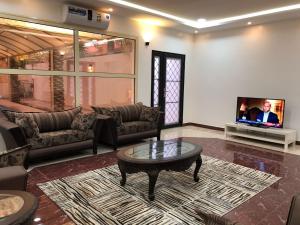 a living room with a couch and a tv at Kendah Chalet in Buraydah