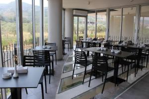 a restaurant with tables and chairs and windows at Le Six Hotel And Resort in Batroûn