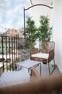 uma varanda com 2 cadeiras e uma mesa em FLORIT FLATS - Chic and Central in a lively but quiet area All walking distance em Valência