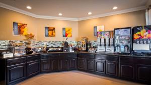 a coffee shop with a counter with a lot of drinks at Best Western Willows Inn in Willows