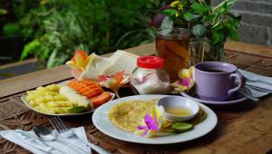 a table with plates of food and a cup of coffee at Nyuh Gading Accommodation Ubud in Ubud +76 photos