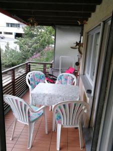 a table and four chairs on a balcony at Quellenhof D04 in Davos