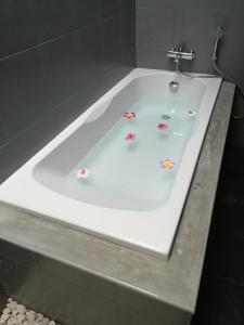 a white bath tub with flowers on it at M.I.N.D. Villa in Chiang Mai
