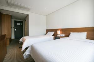 Postel nebo postele na pokoji v ubytování Busan Tourist Hotel