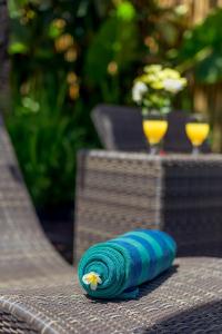 a blue rolled up towel sitting on top of a table at Arama Riverside in Legian