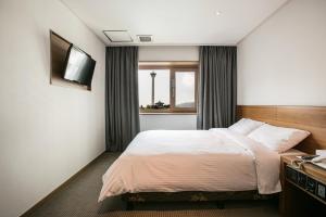 Postel nebo postele na pokoji v ubytování Busan Tourist Hotel