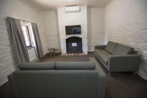 a living room with a couch and a fireplace at Paxton Square Cottages in Burra