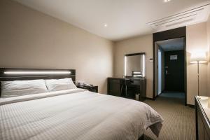 Postel nebo postele na pokoji v ubytování Busan Tourist Hotel