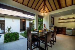 a dining room and kitchen with a table and chairs at Arama Riverside 5 Bedrooms by Villas Direct Bali in Legian