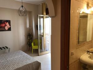 a bathroom with a bed and a sink and a mirror at Le Camere di Rosanna in Marina di Gioiosa Ionica +61 photos