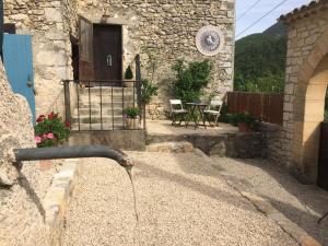 a water fountain in front of a stone building at Mas de la Pauze in Reilhanette