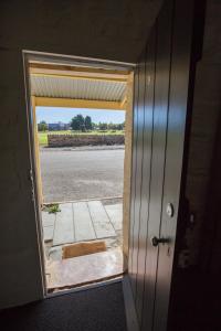 a door that is open to a room with a door at Paxton Square Cottages in Burra