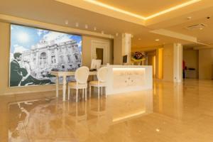 マントンにあるLa Dolce Vita Hotelのテーブルと椅子、大画面テレビが備わる客室です。