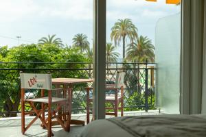 a table and chairs on a balcony with palm trees at La Dolce Vita Hotel in Menton