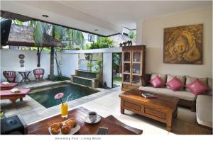 ein Wohnzimmer mit einem Pool in der Mitte in der Unterkunft 2BR Villa Senin - Minggu Villas Seminyak in Seminyak