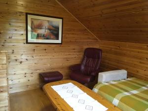 a room with a bed and a chair in a cabin at Søndre Forøya Gård in Tromsø