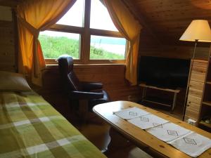 a room with a bed and a desk and a window at Søndre Forøya Gård in Tromsø