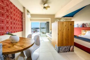 a bedroom with a bed and a wooden table and chairs at Aptera Beach in Amoudara Herakliou
