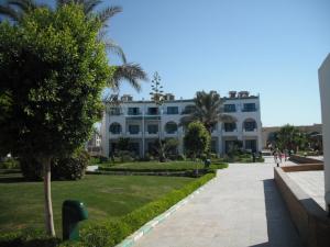 a large white building with palm trees in front of it at Reemyvera in Hurghada