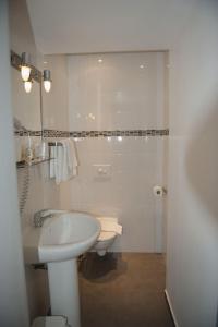 アジャクシオにあるHotel du Palaisの白いバスルーム(洗面台、トイレ付)
