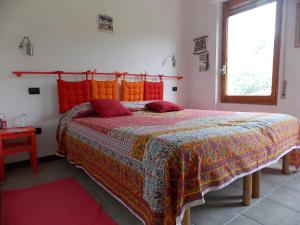 1 dormitorio con 1 cama grande con almohadas de color rojo y naranja en B&B Sette Fratelli en San Gregorio