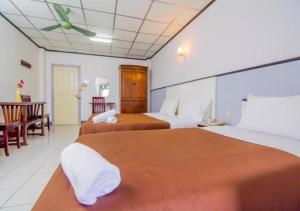 Habitación de hotel con 2 camas y mesa en Sutus Court 3, en Pattaya central