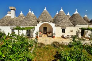 a large white building with pointed roofs at Masseria Trulli e Vigne in Martina Franca
