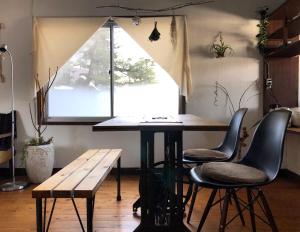 富士吉田市にあるHostel Fuji Matsuyama Baseの窓のある部屋にあるテーブルと椅子