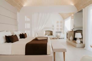 a white bedroom with a large bed and a table at Masseria Muntibianchi AgriResort Restaurant & SPA in Otranto +99 photos