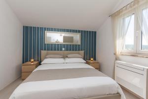 a bedroom with a large bed with blue stripes at Apartments Feel Good in Sukošan