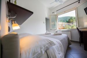 a bedroom with a bed with a large window at Bouganville B&B in Cefalù