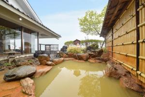 a pond in front of a building with rocks at Kokuya in Shibukawa