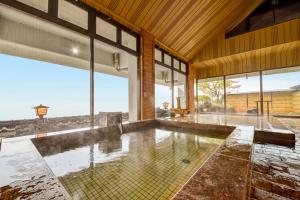 an indoor pool in a house with large windows at Kokuya in Shibukawa