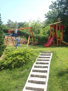 um parque infantil com dois baloiços e um escorrega em Tenerra Lux Apartment em Varna City