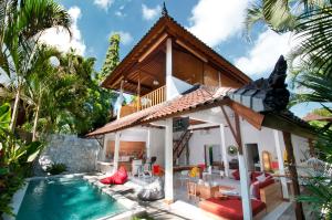 a villa with a swimming pool and a house at 3BR Villa Hari - Minggu Villas Seminyak in Seminyak