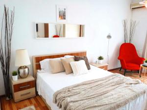 a bedroom with a bed and a red chair at Studio Old Center in Bucharest