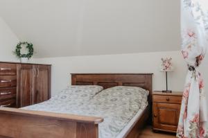 sypialnia z drewnianym łóżkiem i drewnianą komodą w obiekcie Domek Piotr 2 w Stegnie
