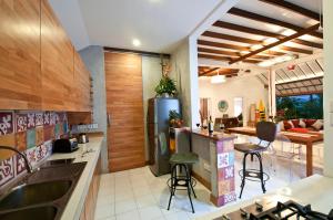 a kitchen with a refrigerator and a table with chairs at 3BR Villa Hari - Minggu Villas Seminyak in Seminyak