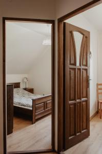 otwartymi drzwiami prowadzącymi do sypialni z łóżkiem w obiekcie Domek Piotr 2 w Stegnie