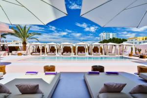 a pool with lounge chairs and umbrellas at Paradiso Ibiza Art Hotel - Adults Only in San Antonio Bay