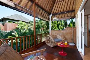an outdoor patio with a table and chairs on a deck at 3BR Villa Hari - Minggu Villas Seminyak in Seminyak