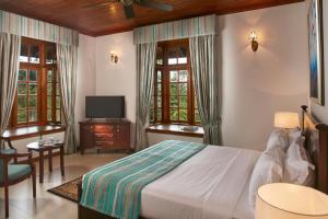 班德勒韦勒Manor House Bandarawela By Seven Angels的一间带床、电视和窗户的卧室