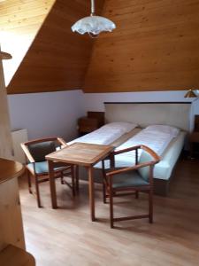 Cette chambre comprend un lit, une table et des chaises. dans l'établissement Magdi apartman, à Keszthely