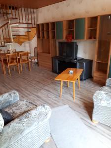 uma sala de estar com um sofá e uma mesa em Magdi apartman em Keszthely