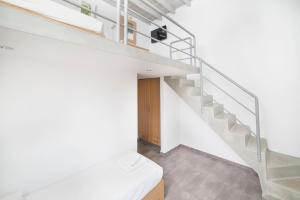 an attic bedroom with a staircase and a toilet at FarOut - BeachResort & Camping in Mylopotas