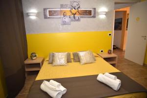 Un dormitorio con una cama amarilla con toallas. en Villa Marzia, en Porto Cesareo