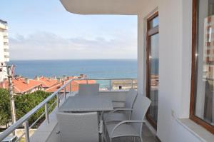 a balcony with a table and chairs and the ocean at Longoz Hotel in Igneada