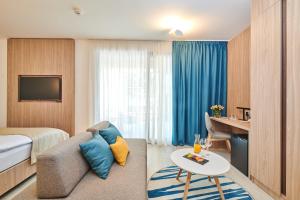 a hotel room with a couch and a table at Garden Suites Umag Plava Laguna in Umag