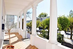 eine weiße Veranda mit Säulen und einem Innenhof in der Unterkunft Ferienwohnungen im Appartementhaus Sellin in Ostseebad Sellin